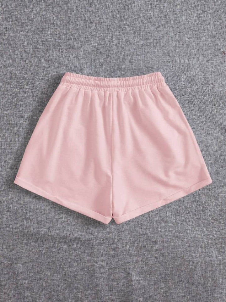 a pair of pink shorts sitting on top of a bed