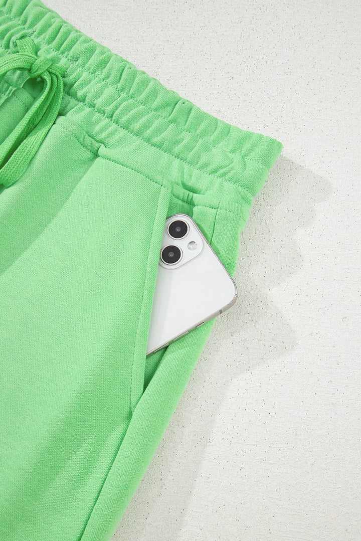Pocket detail of light green French Terry mini skort holding a smartphone, highlighting functionality and convenience at Faith & Co. Boutique.