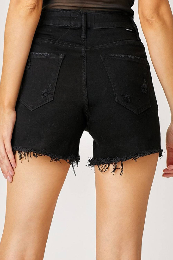 a close up of a person wearing black denim shorts