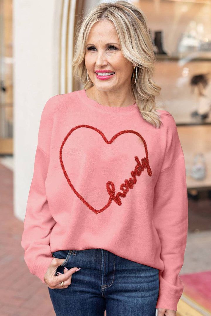 a woman wearing a pink sweater with a heart drawn on it