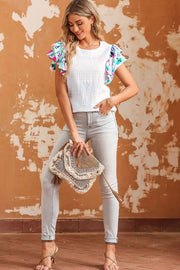 a woman in a white top is holding a purse