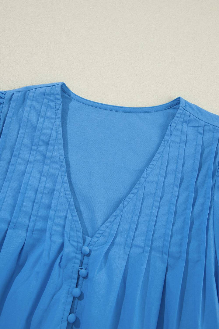 a close up of a blue blouse on a white surface