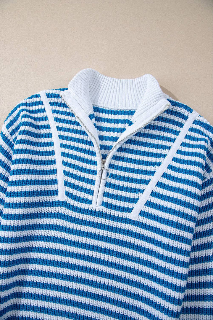 a blue and white striped sweater hanging on a wall