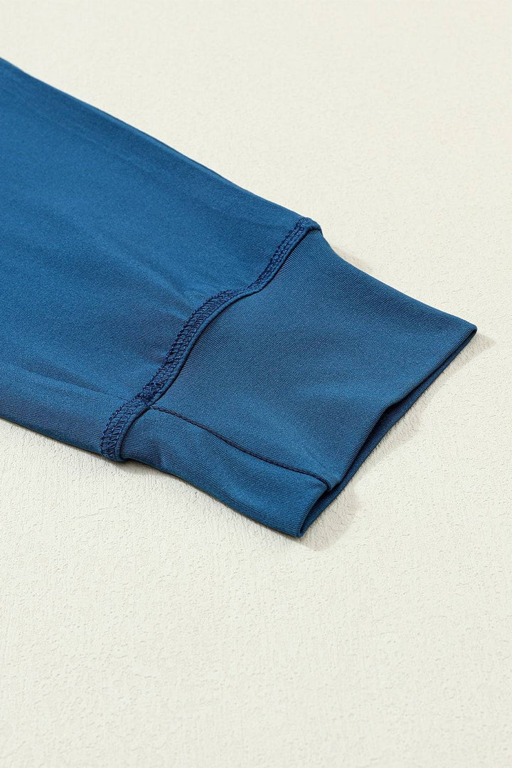 a blue shirt laying on top of a white surface