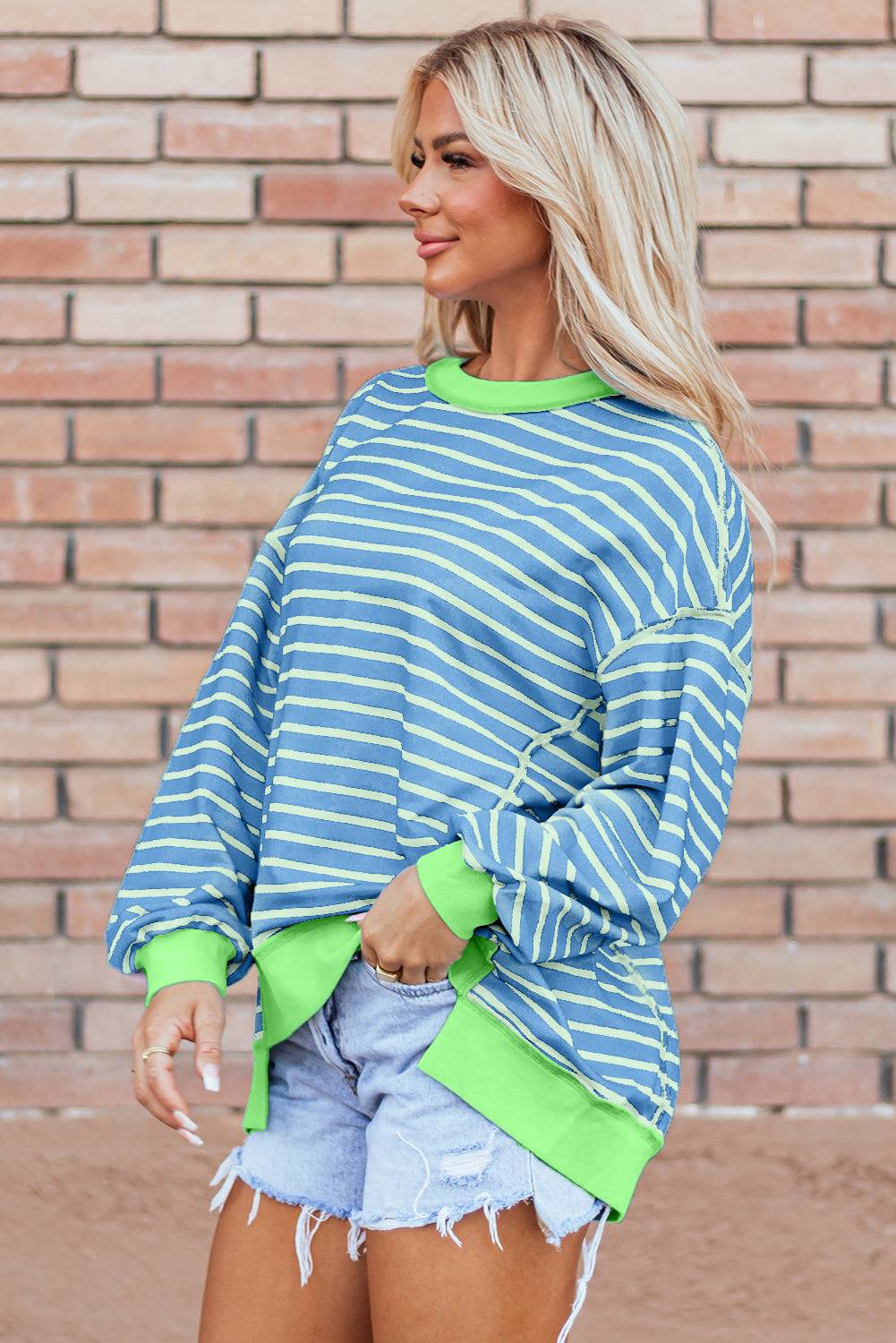 a woman wearing a blue and green striped sweater