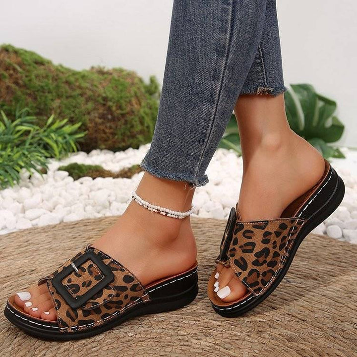 a close up of a person wearing leopard print sandals