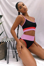 a woman in a black and pink bathing suit