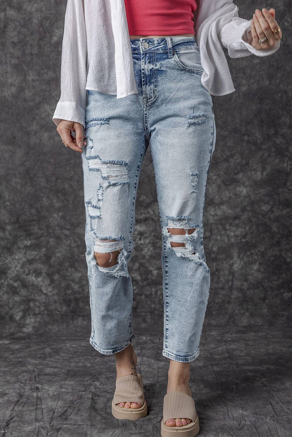 a woman wearing ripped jeans and a white cardigan