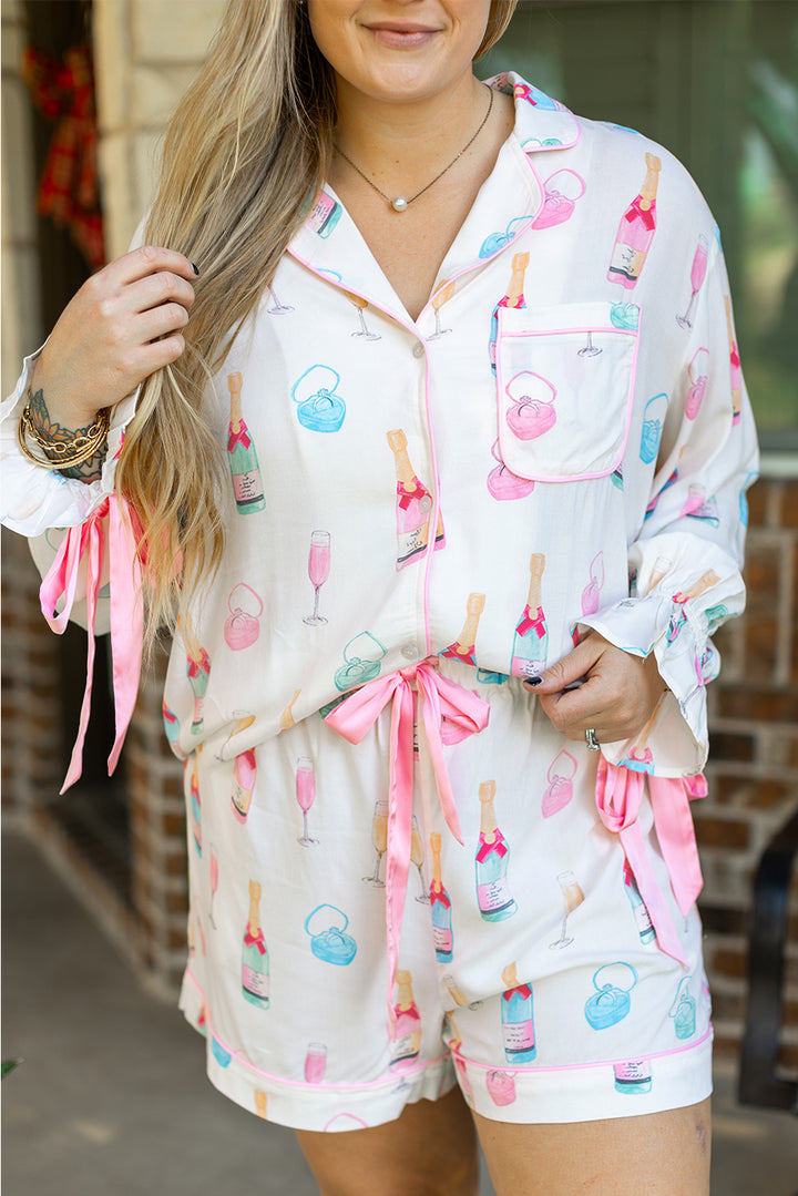 Close-up of White Plus Size Wine Glass Print Bow Knot Pajama Set at Faith & Co. Boutique, highlighting pink trim, chest pocket, and wine glass motifs.