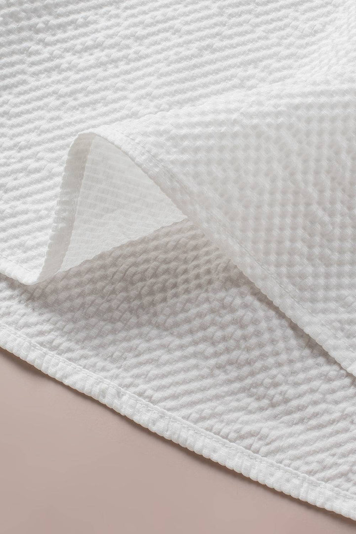 a close up of a white blanket on a bed