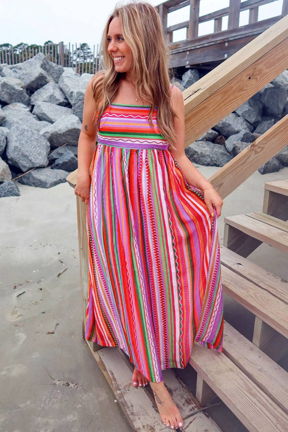 a woman in a colorful dress standing on a beach