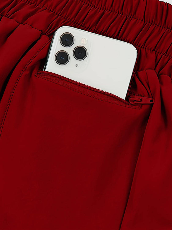 a cell phone sticking out of the pocket of a pair of red pants