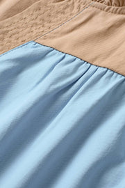 a close up of a blue and tan bedspread