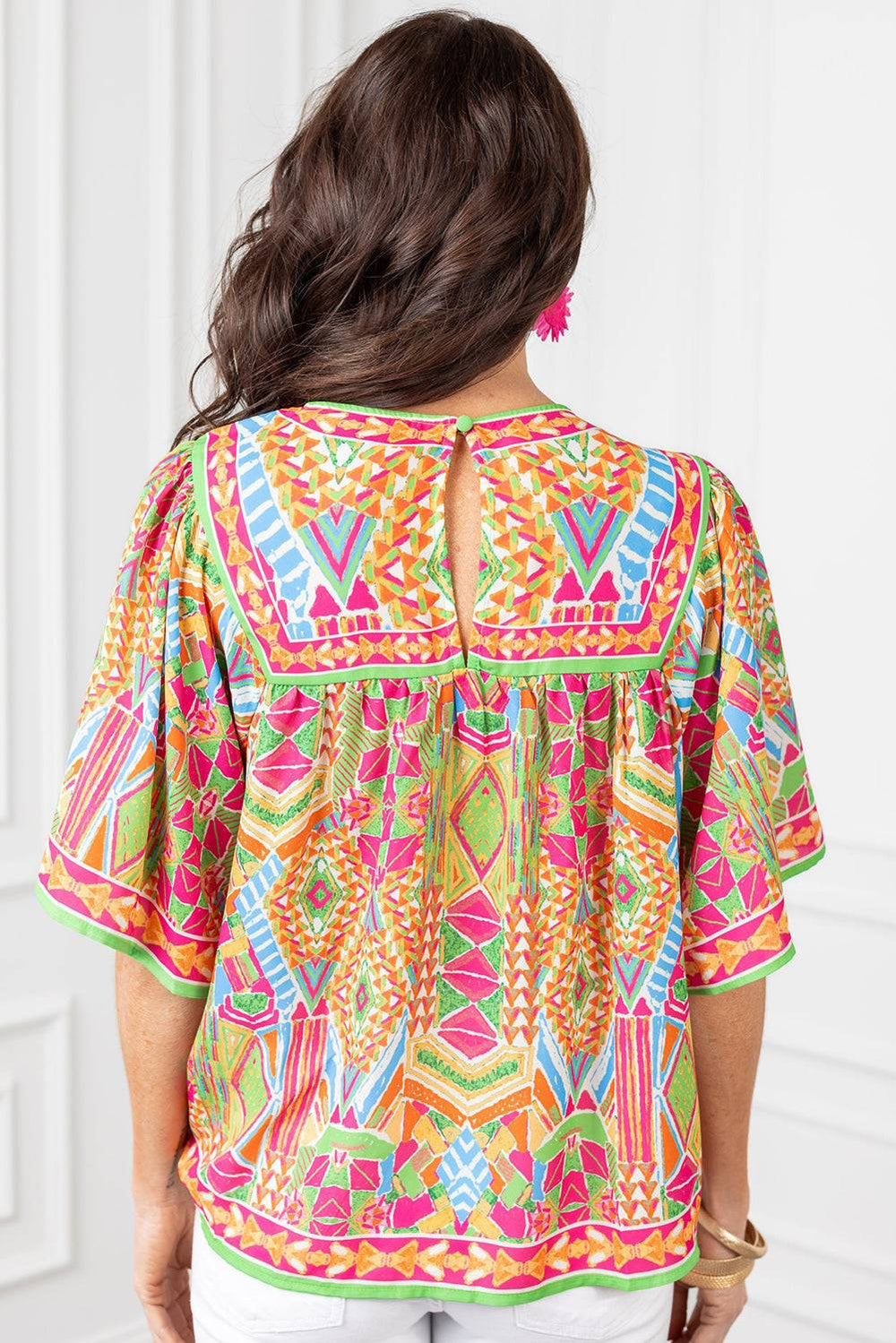 the back of a woman wearing a colorful top