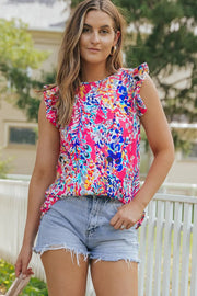 a woman wearing a colorful top and denim shorts