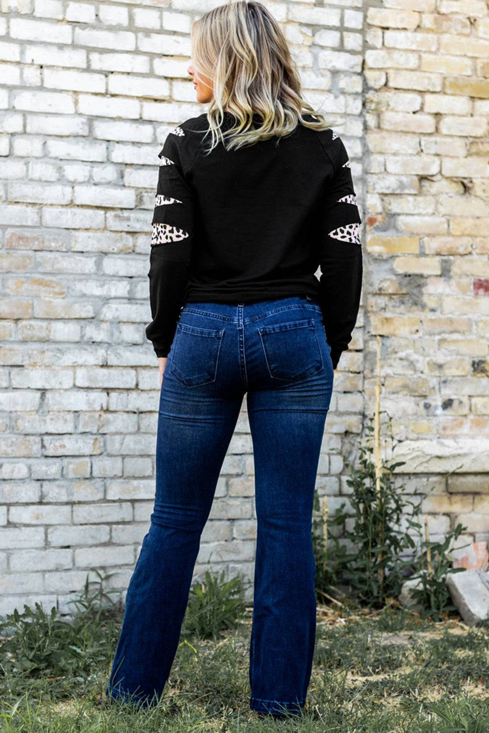 a woman standing in front of a brick wall