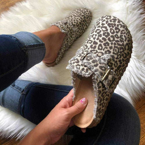 a woman's feet wearing leopard print slippers
