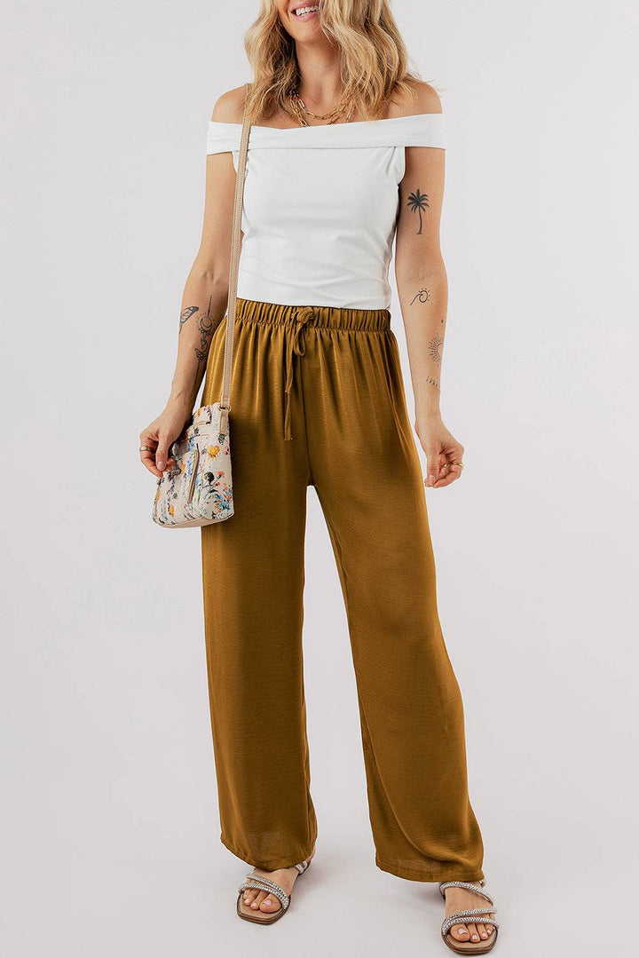 a woman in a white top and brown pants