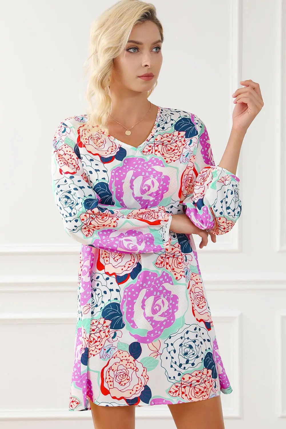 a woman in a floral dress posing for a picture