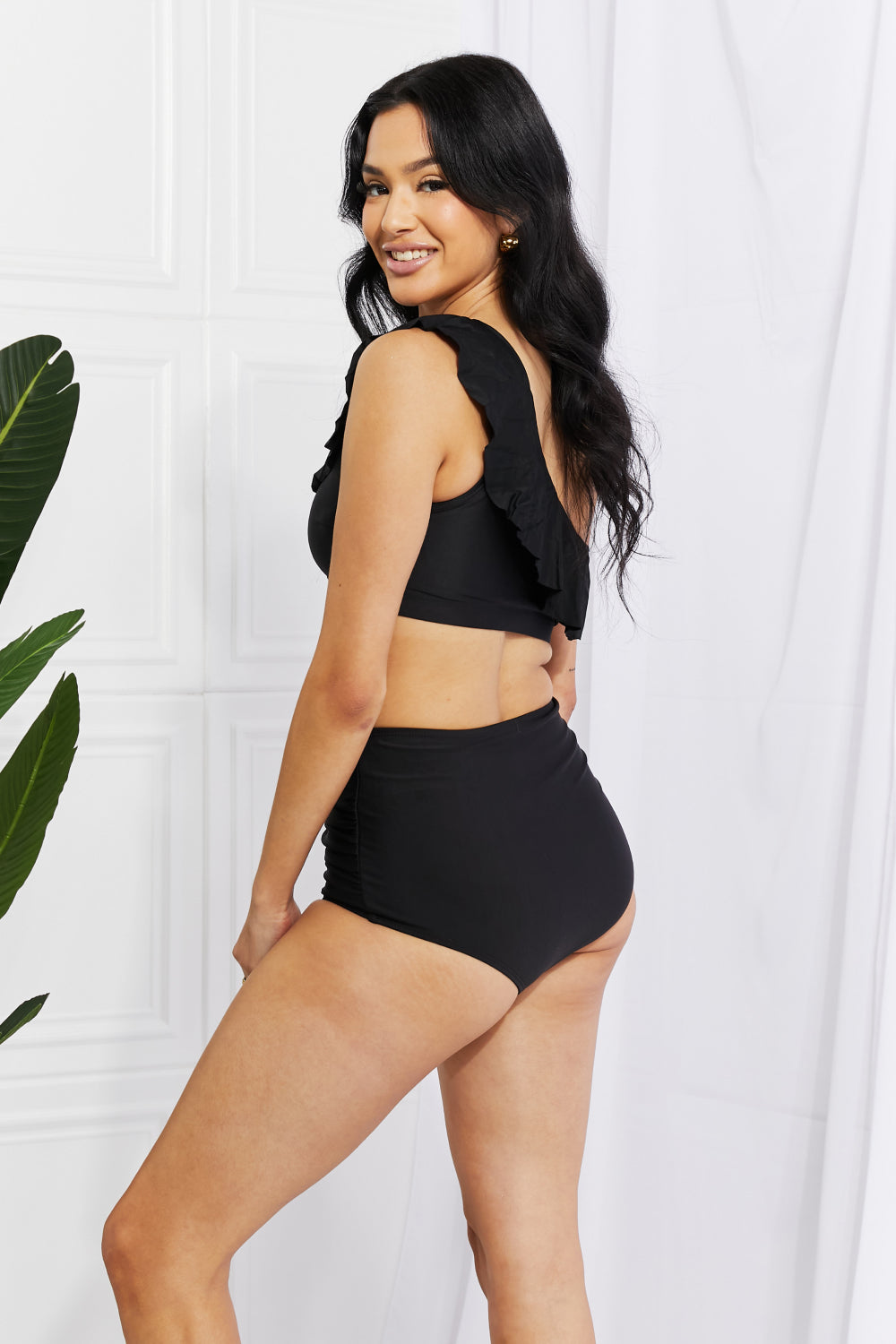 a woman in a black swimsuit posing for the camera