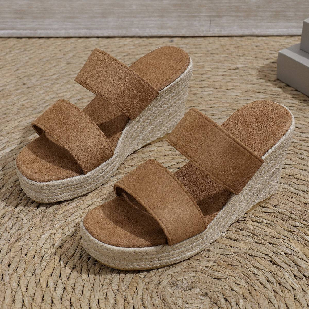 a pair of brown sandals sitting on top of a rug