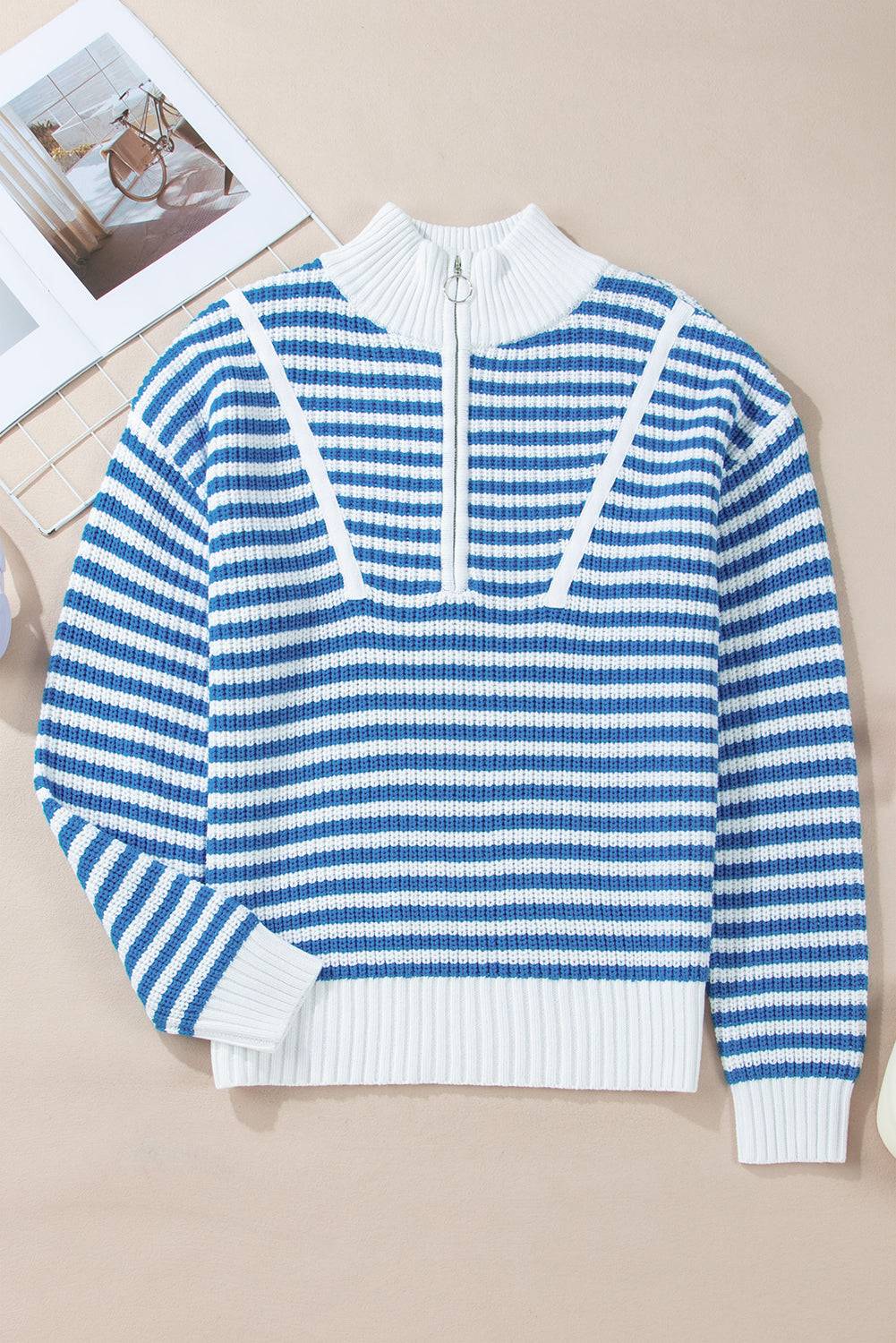 a blue and white sweater sitting on top of a table