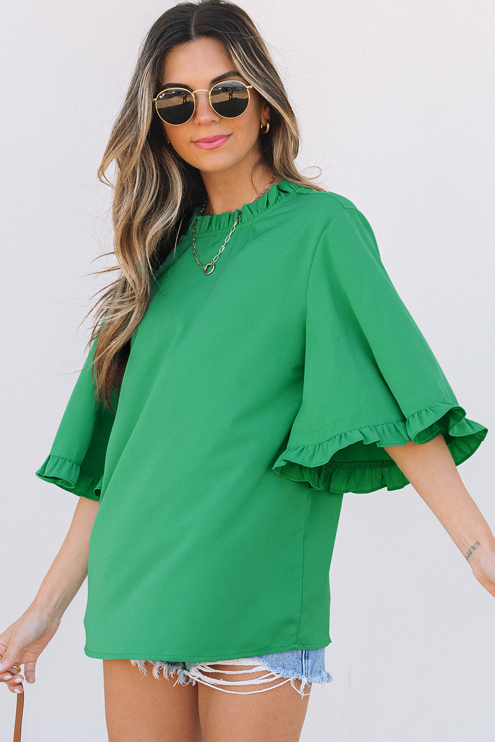 Green Frilly Round Neck Wide Half Sleeve Blouse styled with sunglasses and denim shorts, perfect for Southern Belle summer vibes.