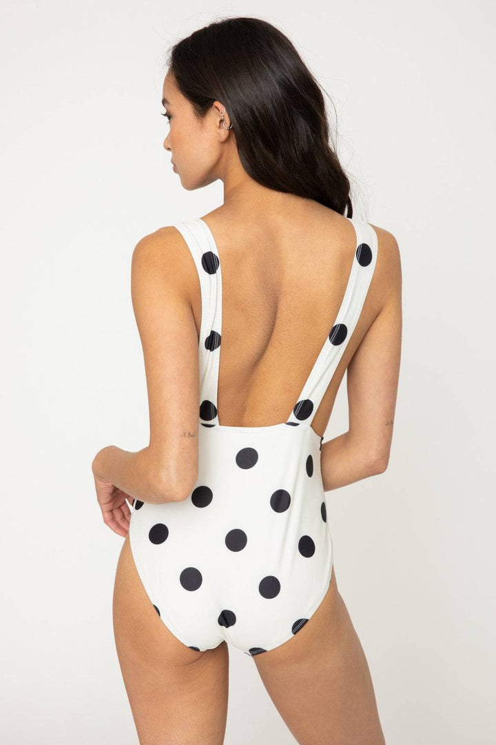 a woman in a white polka dot swimsuit