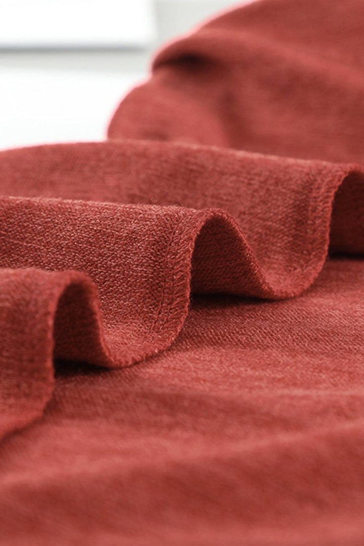 a close up of a red blanket on a bed