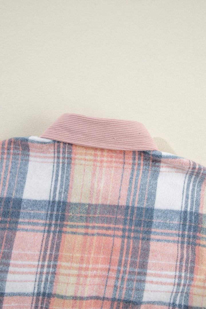 a pink and blue plaid jacket hanging on a wall