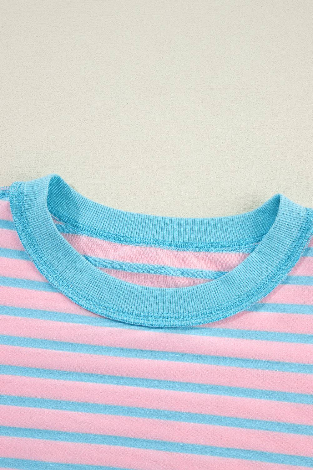 a pink and blue striped shirt hanging on a wall