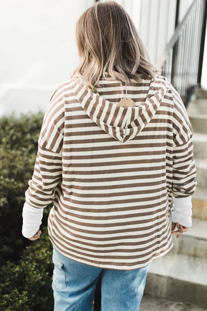 a woman wearing a striped hoodie and jeans