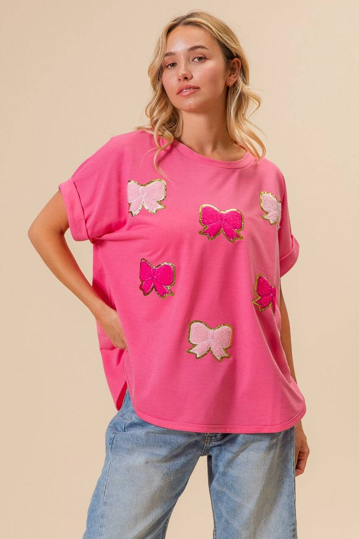 a woman wearing a pink top with pink butterflies on it