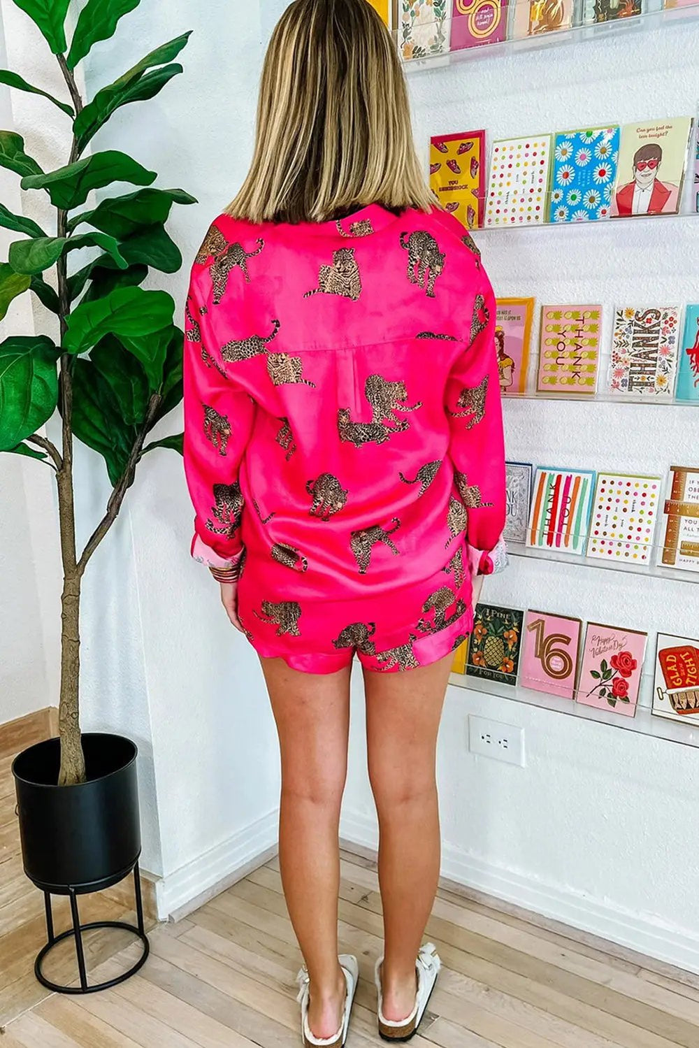 a woman standing in front of a wall with pictures on it