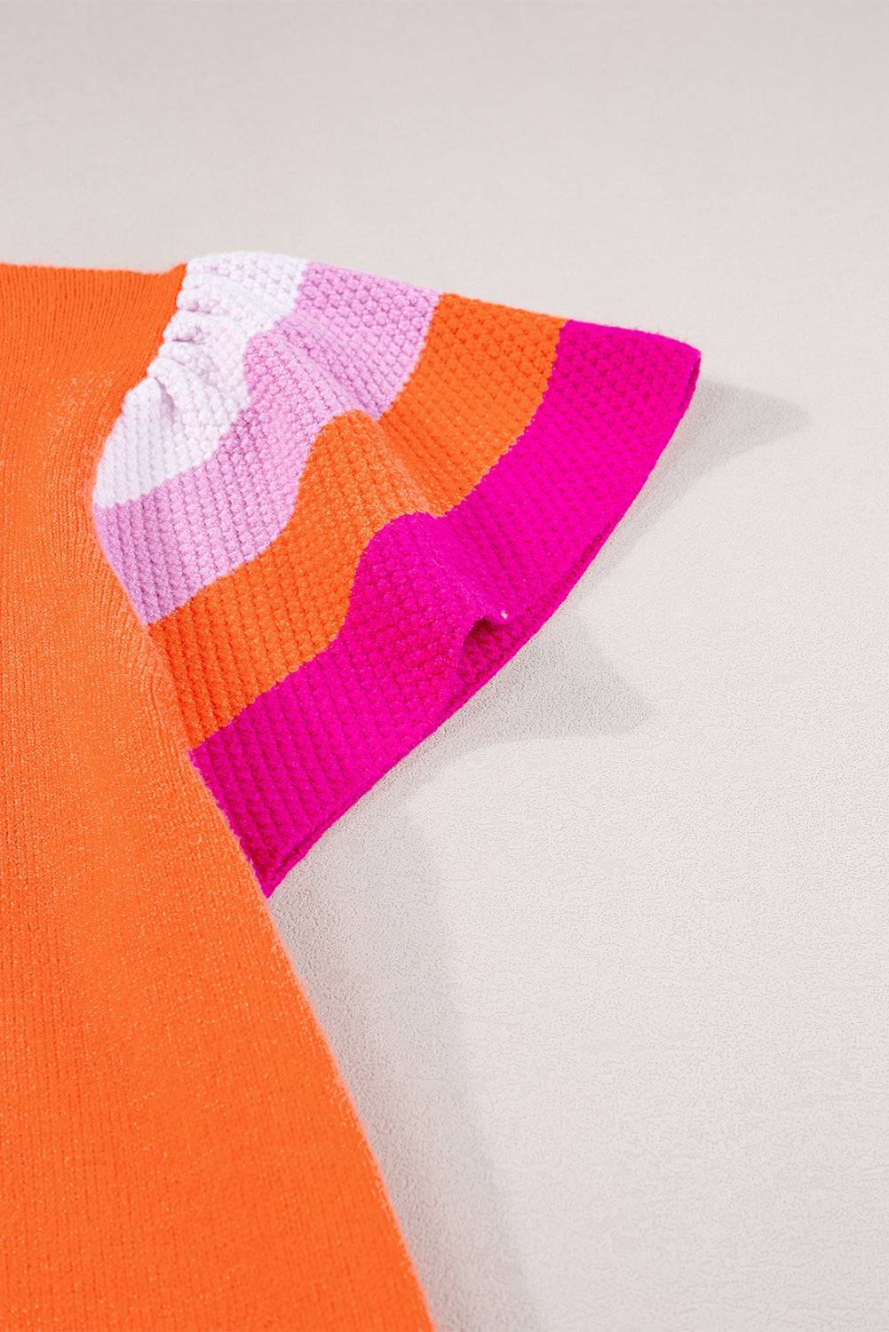 an orange sweater with a pink and orange stripe on it