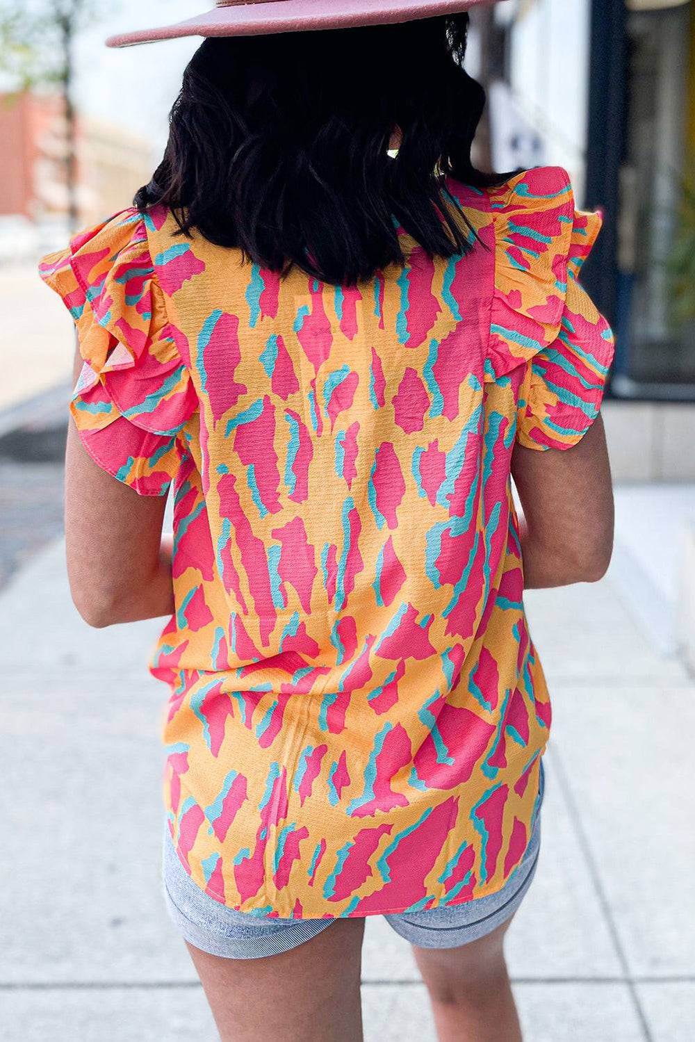 a woman wearing a pink hat and a yellow top