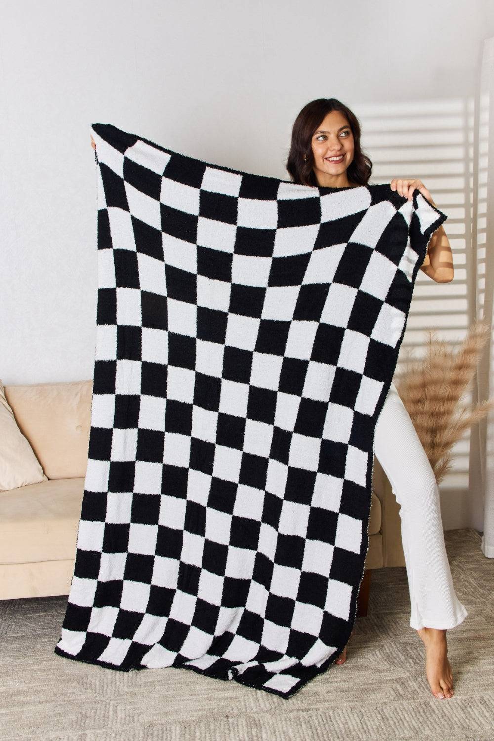 a woman holding a black and white checkered blanket