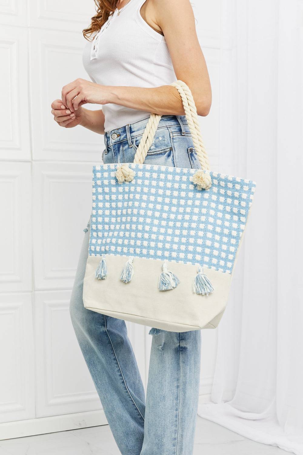 a woman holding a blue and white tote bag