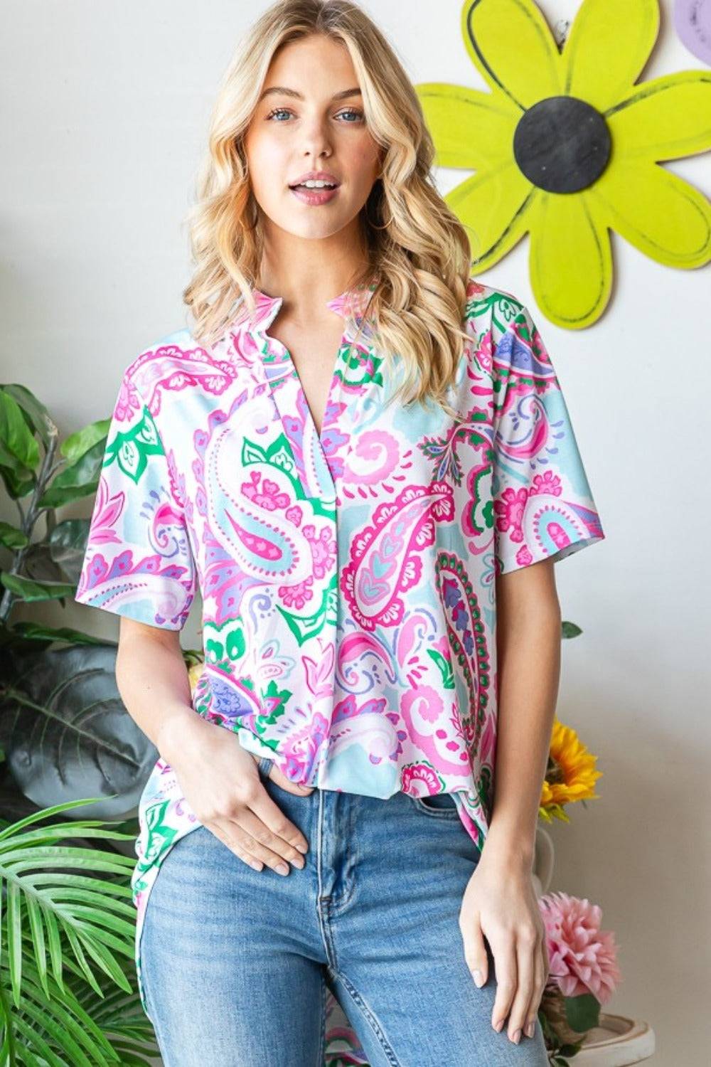 a woman standing in front of a flower