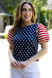 a woman wearing white shorts and an american flag shirt