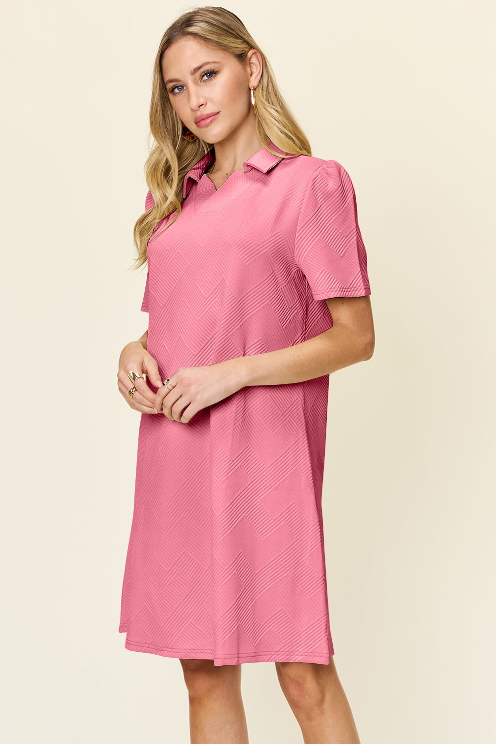 a woman wearing a pink dress with short sleeves