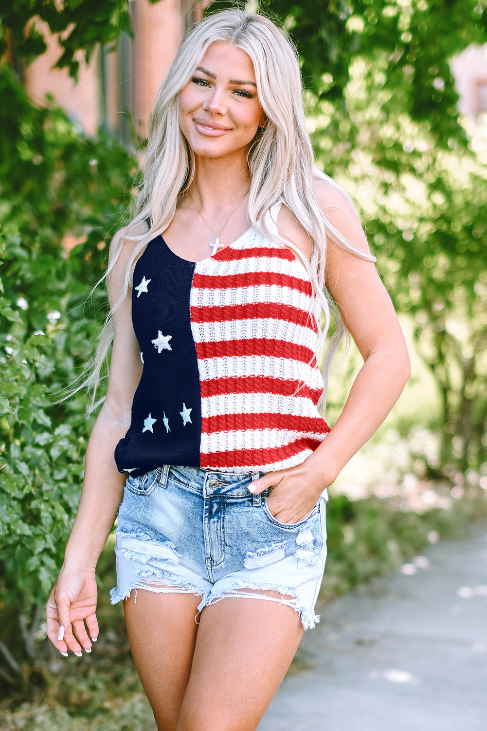 a woman wearing a patriotic tank top and denim shorts