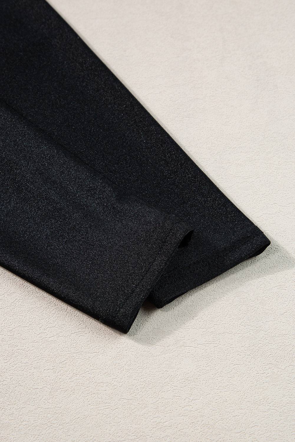 a black tie laying on a white surface