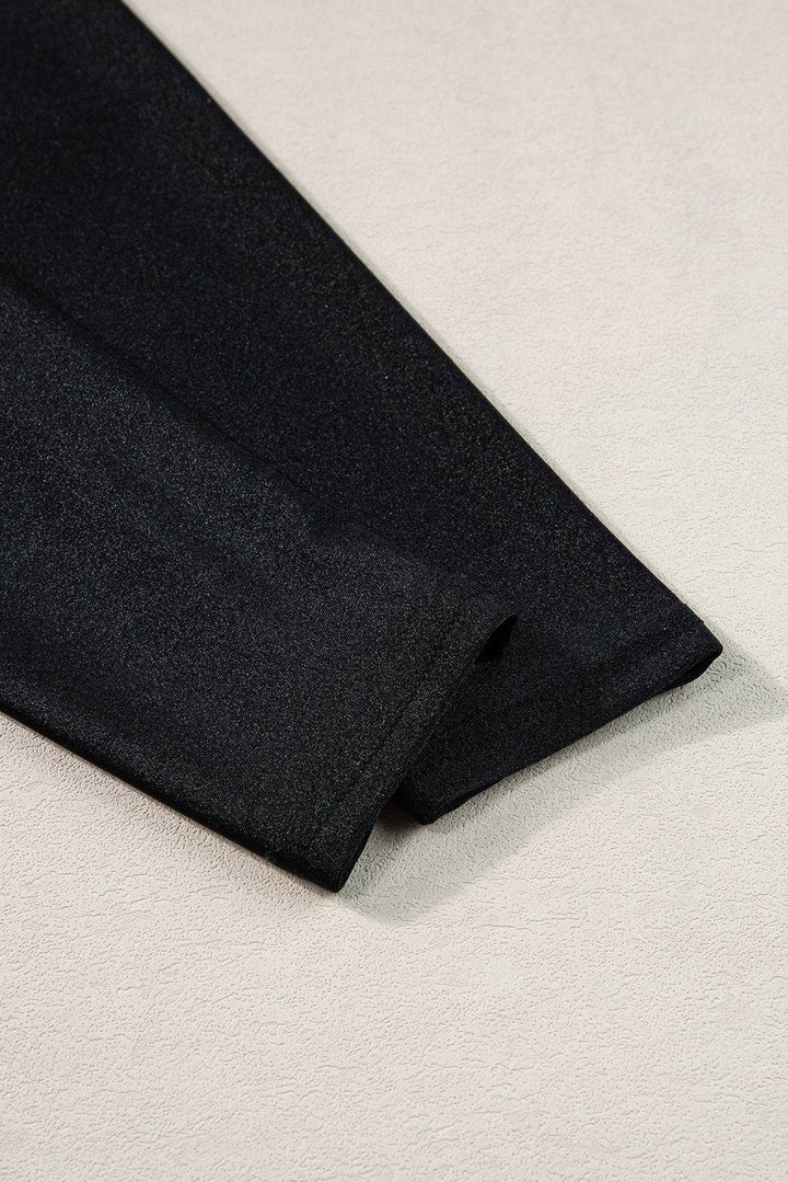 a black tie laying on a white surface