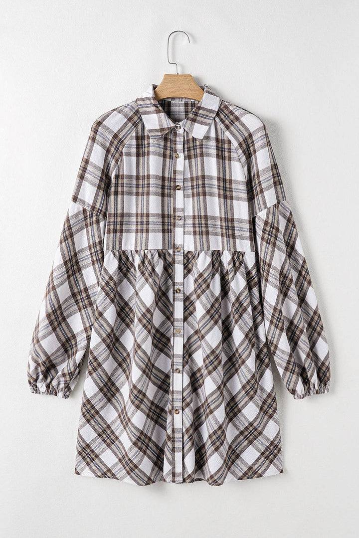 a white and brown plaid shirt hanging on a hanger