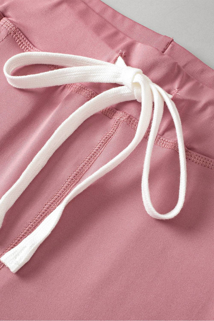 a close up of a pink shorts with a white tie