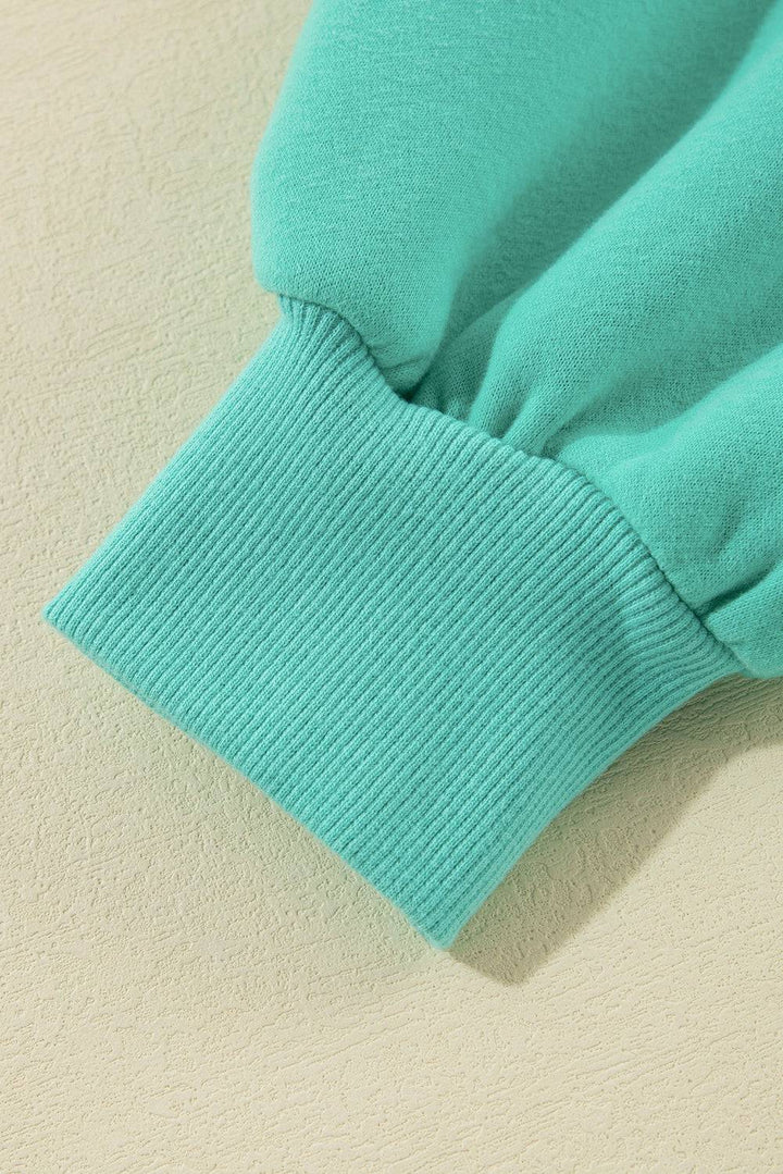 a close up of a green shirt on a white surface