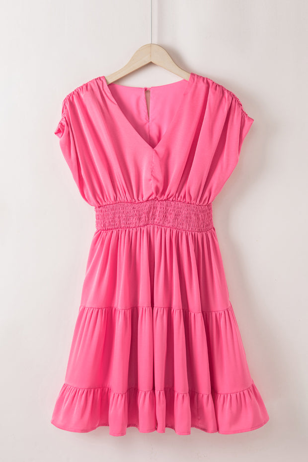 a pink dress hanging on a white wall