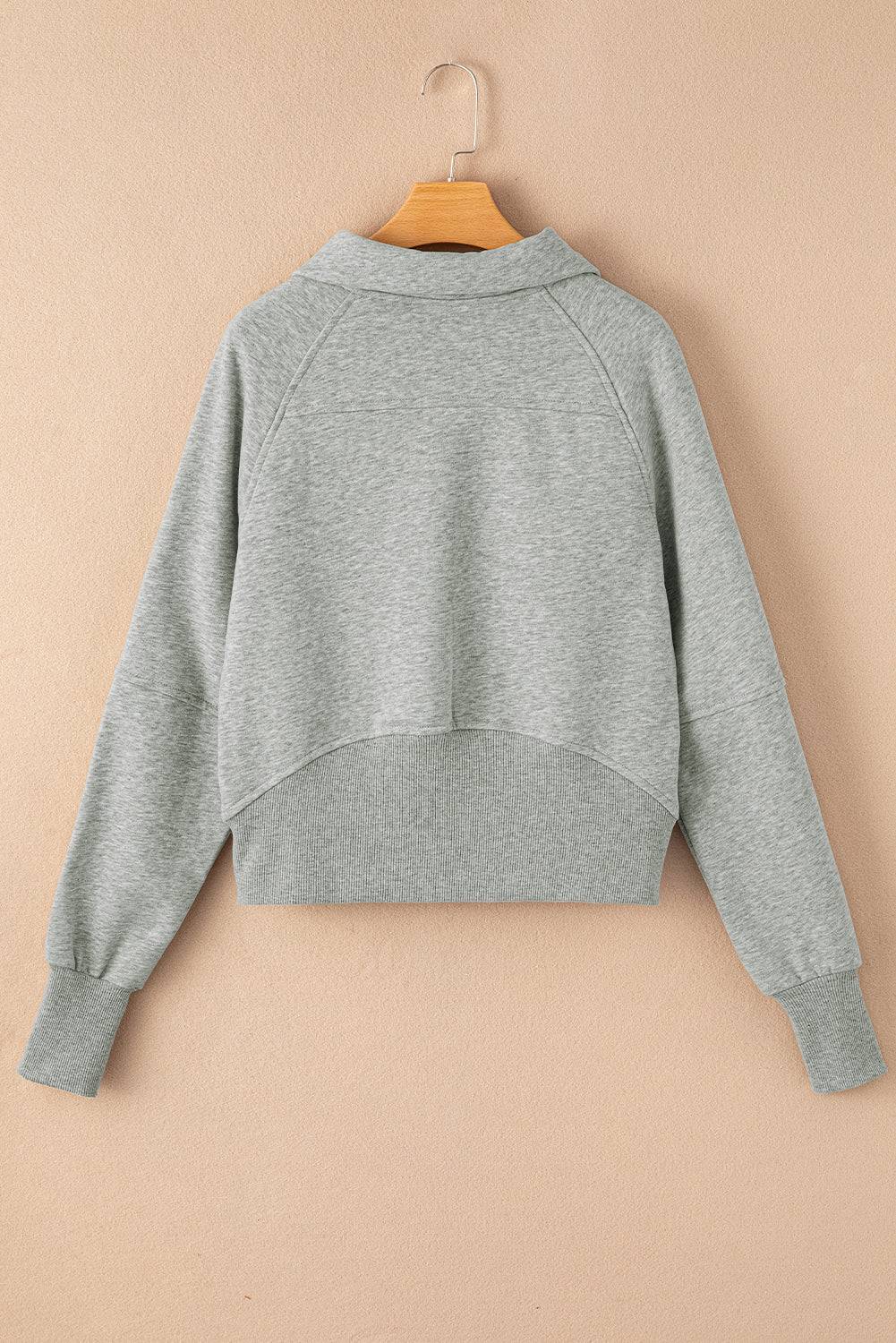 a gray sweatshirt hanging on a hanger