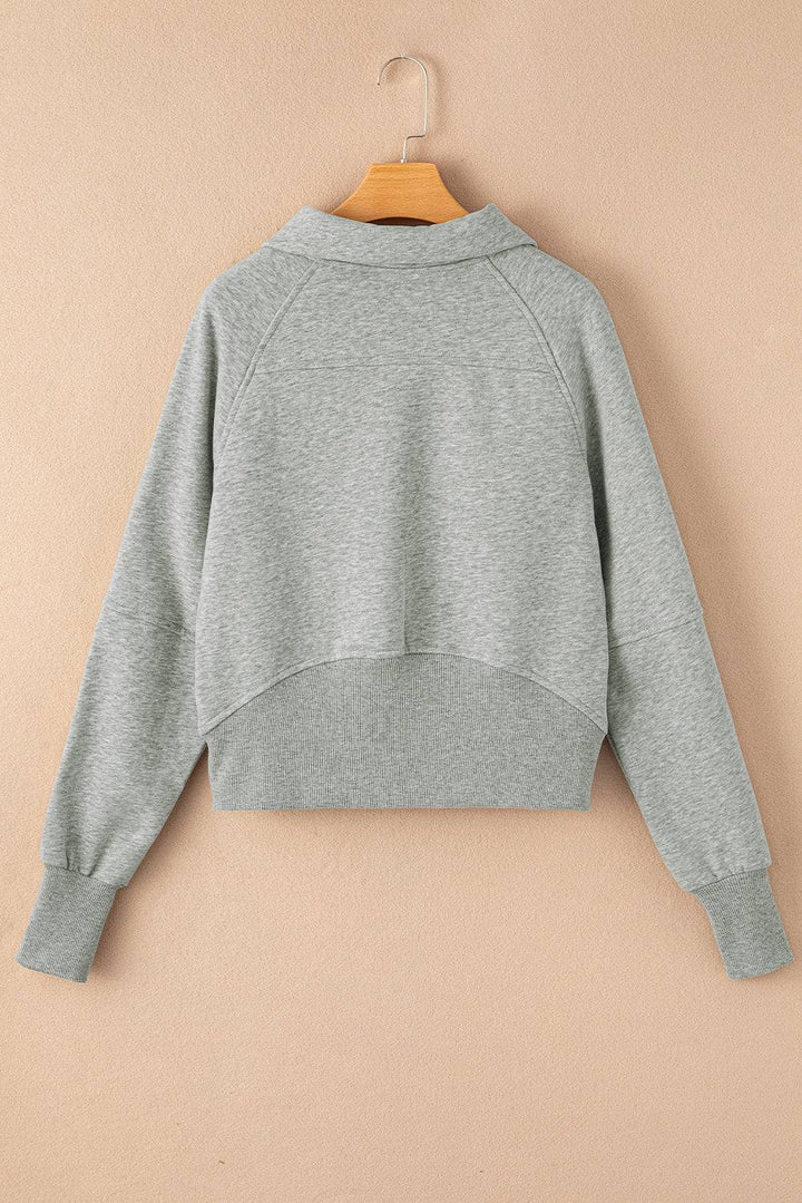 a gray sweatshirt hanging on a hanger